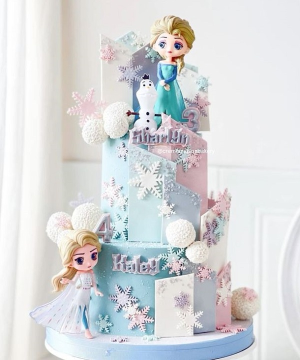 Bánh Elsa 2 tầng với hình ảnh công chúa Elsa đứng trên đỉnh bánh.