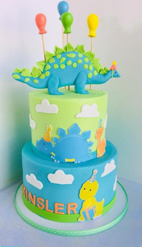 Bánh sinh nhật bé trai với khủng long 2 tầng, màu xanh dương nổi bật.