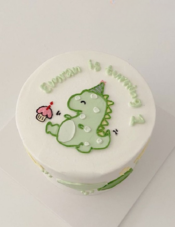 Mẫu bánh kem sinh nhật với hình vẽ khủng long đáng yêu bằng kem tươi.