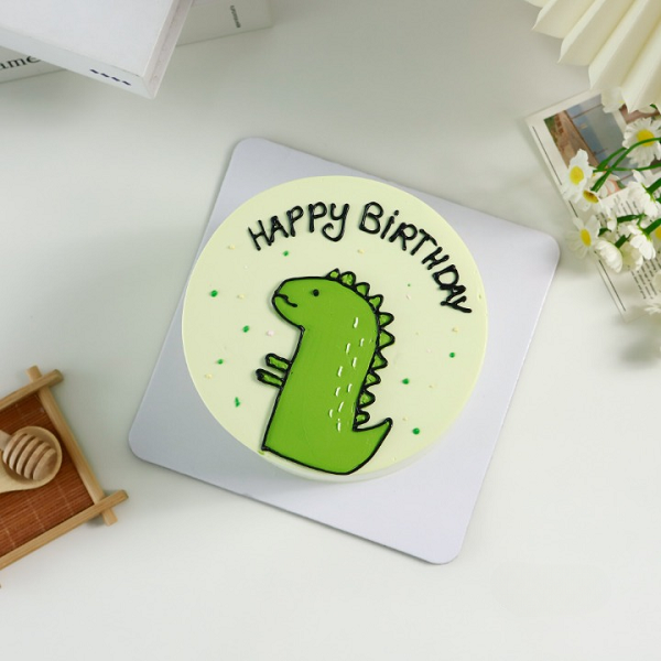 Bánh kem tròn với hình vẽ khủng long xanh lá đáng yêu.