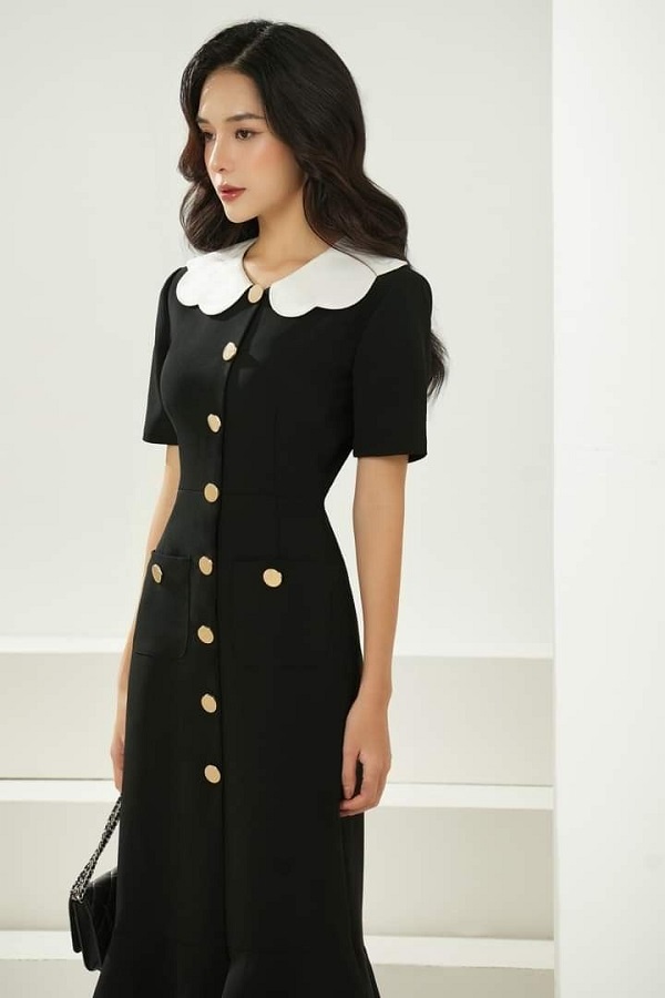 Chiếc đầm ôm body màu đen với phần cổ trắng nổi bật, thiết kế tôn dáng giúp người mặc trông sang trọng.