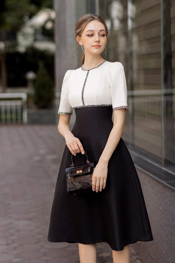 Mẫu đầm dáng chữ A phối hai màu đen trắng hài hòa, phần thân trên ôm nhẹ, chân váy xòe giúp tôn dáng và tạo cảm giác thon gọn.