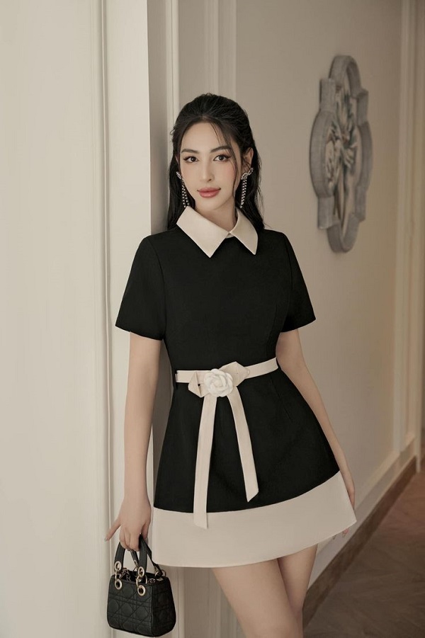 Chiếc đầm phối màu trắng ở cổ, phần dưới chân váy và thắt eo hoa mang lại phong cách thời trang hiện đại và cuốn hút.