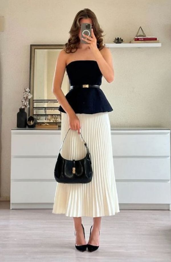 Váy đen pha trắng xếp ly mềm mại tạo sự nữ tính và thanh lịch, phù hợp cho nhiều dịp